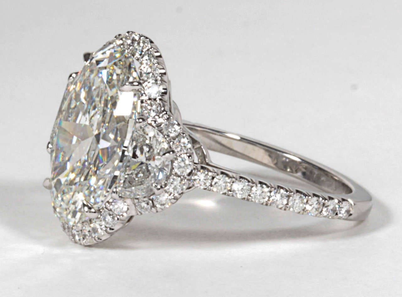 The most brilliant GIA certified (J color - SI2 clarity) 5.13 carat Oval cut diamond set in a custom halo mounting with half moon side diamonds. 

1.74 carats of diamonds set in the platinum mounting.

A unique and stunning ring!