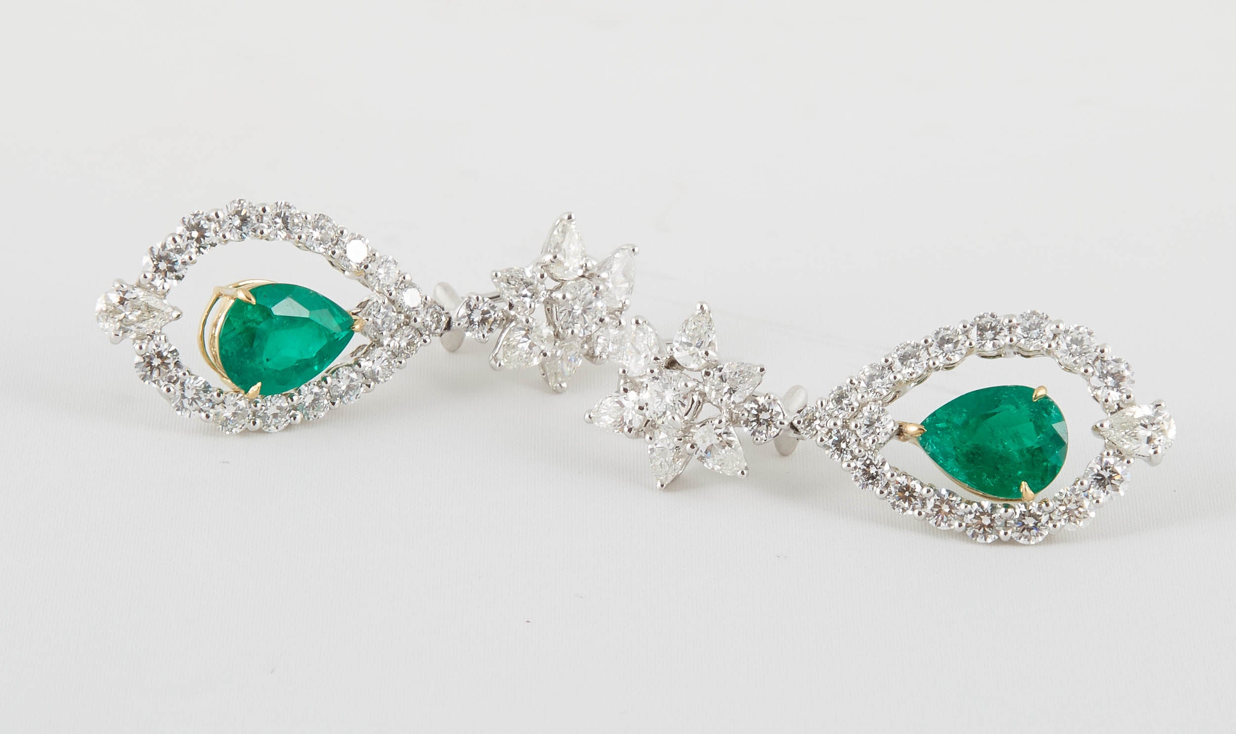 6.05 carats of Fine Colombian Emeralds

8.82 carats of white brilliant pear shaped and round diamonds.

Platinum and 18k yellow gold.