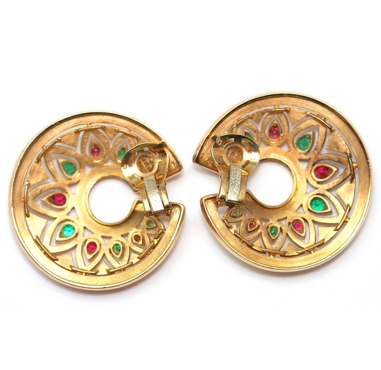 CARTIER ‘Tandjore’ circa 1980
Earclips in openwork sculpted gold hoop with ruby and emeralds, signed and numbered 651201, diameter 40mm, with Cartier pochette (51,45 grams)