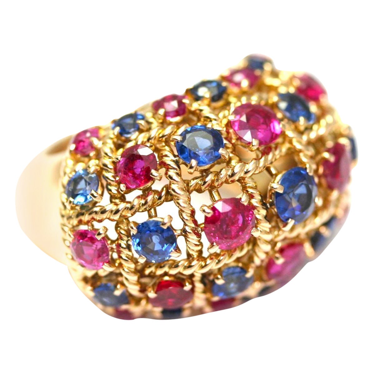 CARTIER CIRCA 1950
Dome ring in yellow gold set with rows of alternated round cut rubies and sapphires, signed, maker’s mark, ring size 6.3/4, with Cartier box (21.2 grams)