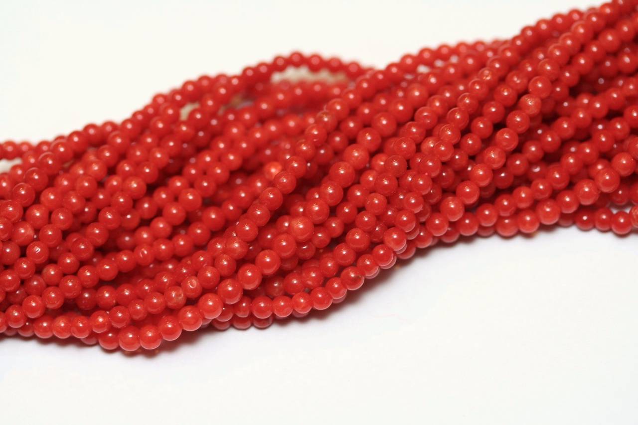 Seventies Necklace with 24 twisted rows of Sardinia red coral beads, yellow gold clasp set with diamonds (93.05 grams)