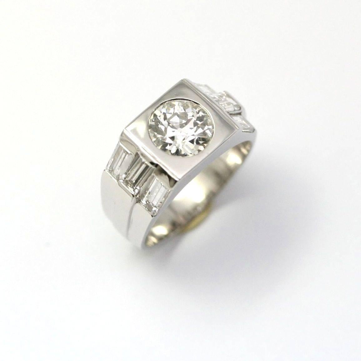 Circa 1930 signet ring in platinum set with a 1.57 carat round diamond in color I/J, shouldered with six baguette diamonds weighing 1.18 carat in total, ring size 6 1/4 (13,15 grams)