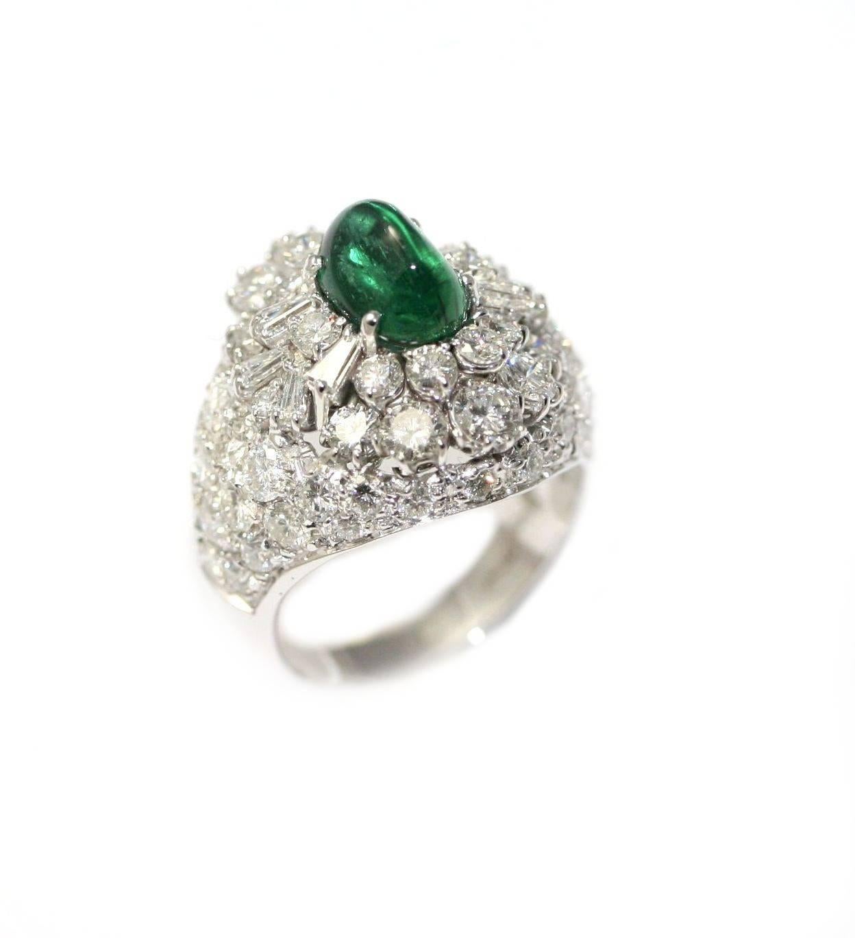 Dome ring in withe gold set with a sugarloaf cut emerald of 2.68 carats, with very nice green color. The mounting is set with 4,5 to 5 carats of diamonds round and tapers cut. 
The ring size is : 57 (French size) --> 8 (US size). it is resizable.