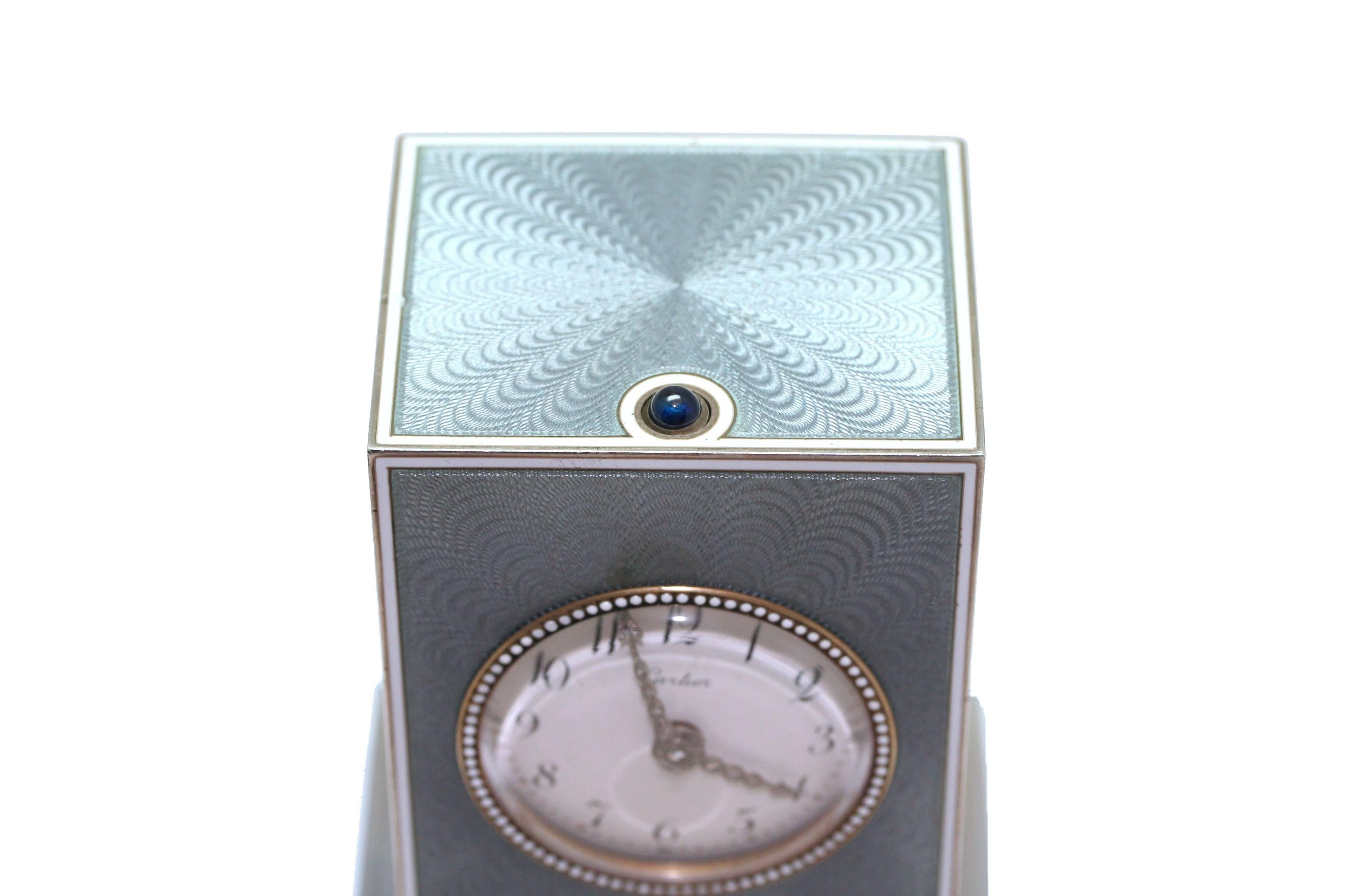 Pendulette in blue enamel, sapphire, brillants, from the beginning of the XXè century. Cubic form, with quarter repeater on demand, ring operated by a push button, grey agate rectangular base, dial with roman numerals, pink-cut diamond studded