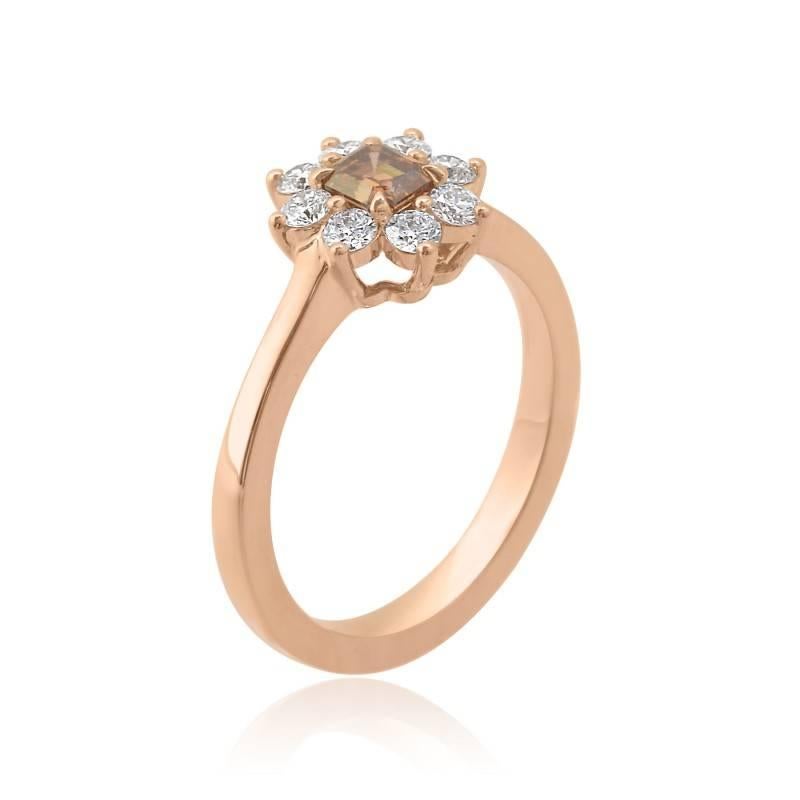 A simply stunning 0.32 carat GIA Certified Emerald Cut Fancy Dark Orange Brown diamond, mounted with a halo of prong set round brilliant diamonds in 18K Rose Gold. There are an additional 8 colorless D-F color round brilliant diamonds, with a