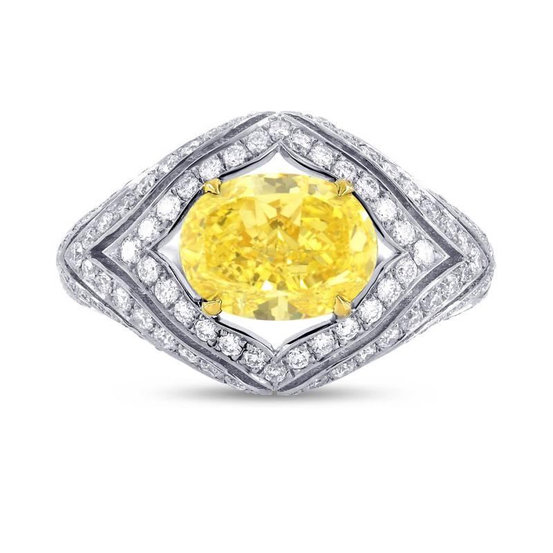 A special diamond ring with a floating center stone, boasting a magnificent 2.24 carat GIA Certified oval cut natural fancy intense yellow, VS2 diamond, surrounded by an assortment of round colorless diamonds, set in 18K White and Yellow gold.
