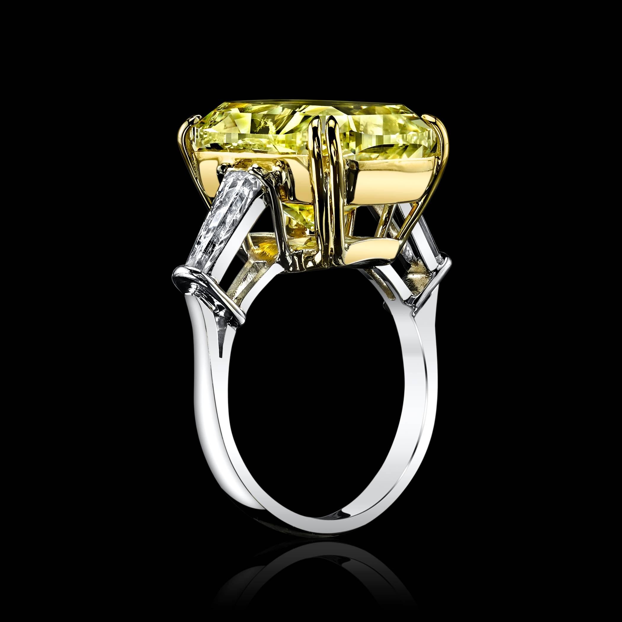 This 17.49 Fancy Light Yellow Diamond Ring is a one-of-a-kind special ring. The center stone is a beautiful Canary Yellow Diamond set in Platinum and 18K Yellow gold, adorned by a pair of tapered colorless Diamonds on both sides. The center stone is