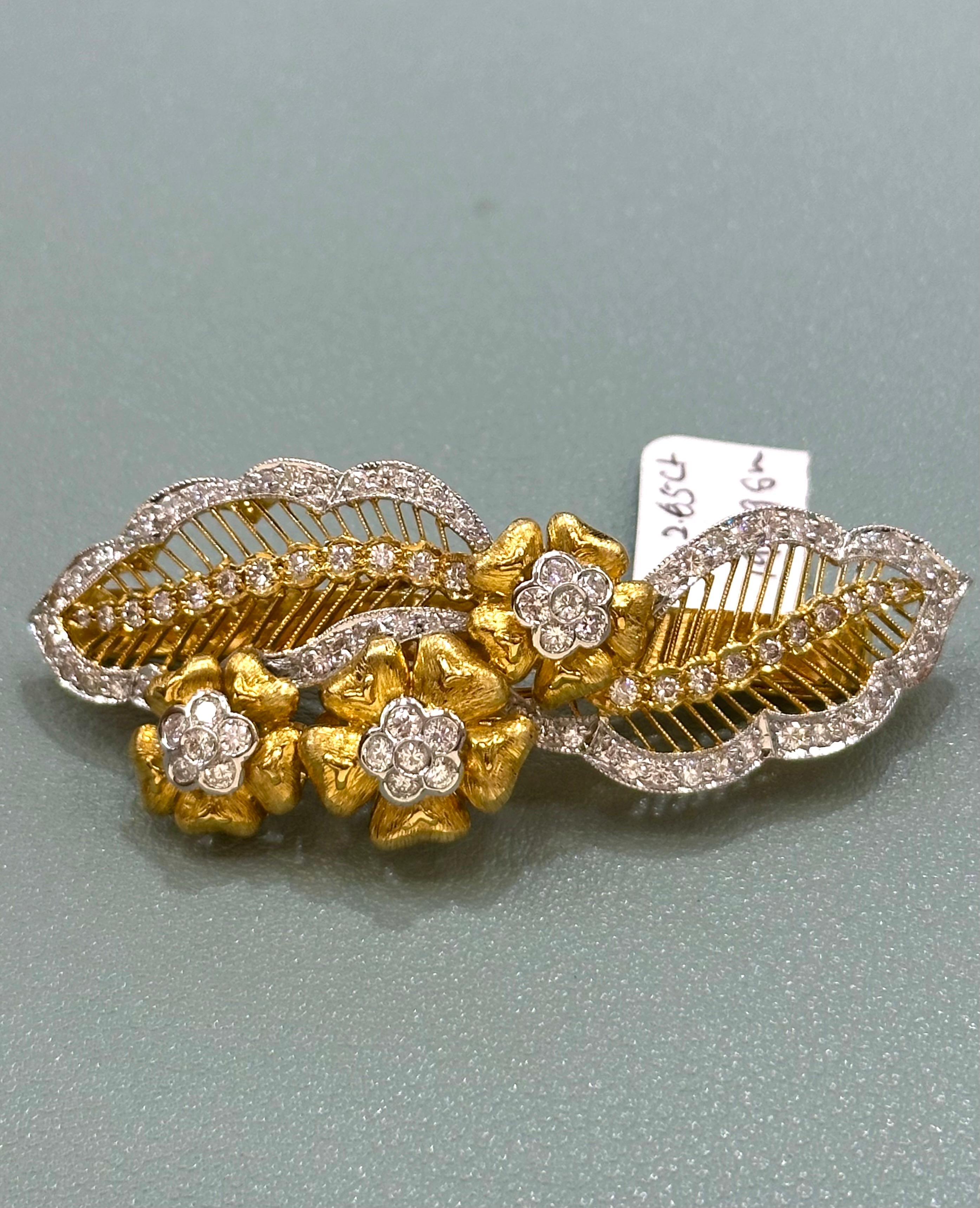 Trois fleurs à cinq pétales serties entre deux feuilles luxuriantes en or jaune avec diamants. 

Poids du diamant : 2.65 cts 

Poids total de 17,796 grammes 