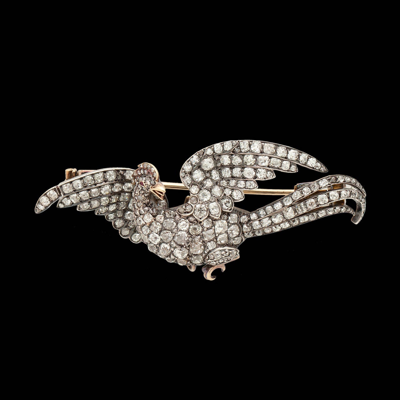 Antique 18Kt Gold Brooch Topped in Silver, Features approximately 10.00 carats of Old Cut Diamond Pave Set on a Stylized Phoenix. This piece is from the 19th century. The brooch is about 2.5 inches long and weighs 16.6 grams.