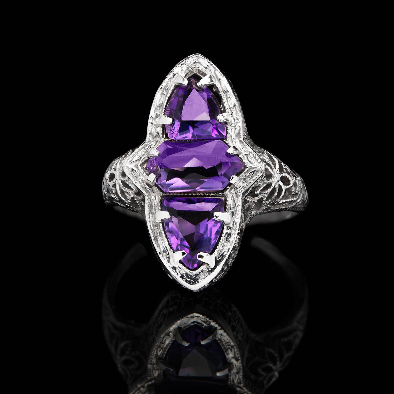 Striking Filigree Ring Crafted in 14Kt White Gold with 21mm Long Navette Shaped Face Featuring 3 fancy-cut Amethysts. The ring is a size 5.0 and weighs 2.5 grams.