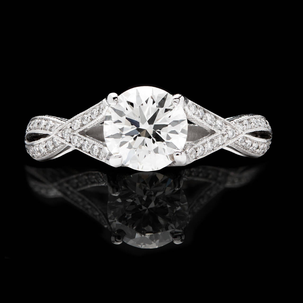L'incastonatura Tacori Ribbon Twist presenta un diamante rotondo taglio brillante GIA da 1,02 carati, di colore F e internamente senza difetti. La montatura è impreziosita da 46 diamanti rotondi taglio brillante. L'anello è una misura 7.0 e pesa 3,5