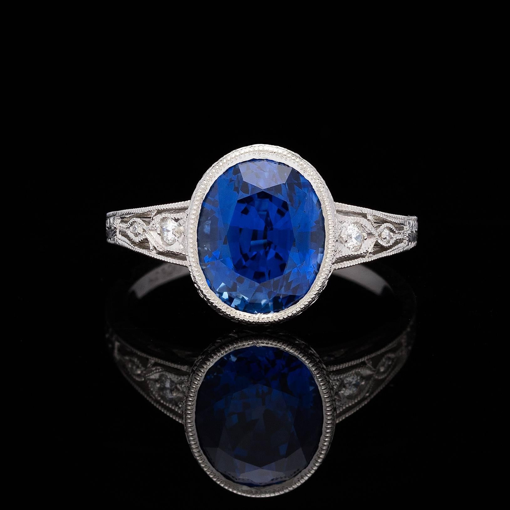 Stunning AGL 4.29 carats Sri Lanka Ceylon blue oval mixed-cut sapphire is bezel-set in a vintage style platinum setting with milligrain and filigree details, and accented by four round brilliant-cut diamonds totaling 0.05 carat.  The ring is