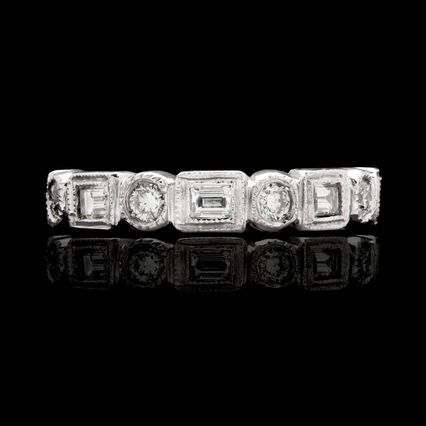 Handcrafted platinum eternity band features alternating round brilliant and baguette-cut diamonds with milgrain detailing on the bezels. The G/H color, VS clarity diamonds total 0.64cttw. The ring is currently a size 3 3/4 and can be sized up or