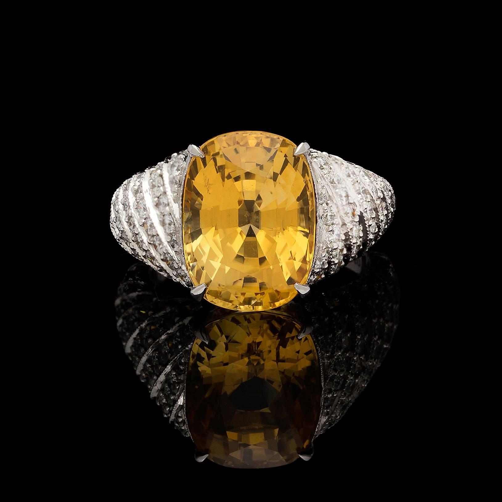 The platinum dome ring centers an oval-shaped yellow sapphire weighing 10.60 carats, with the wide, tapering mounting set with round brilliant-cut diamonds, weighing in total an estimated 3.00 carats. The ring is currently a size 6, can be sized up