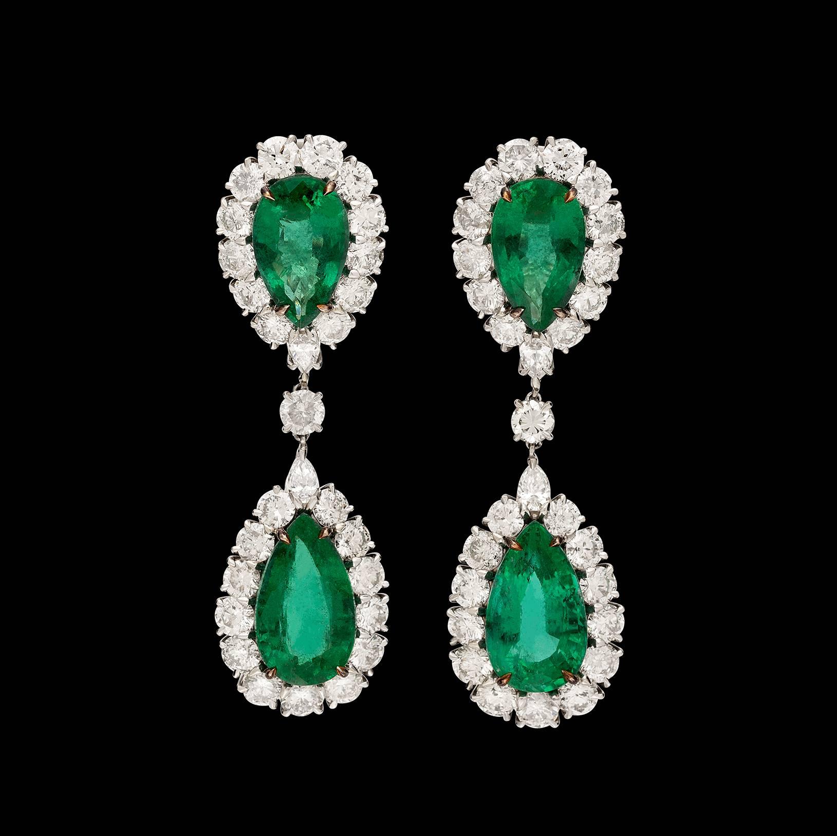 Show-stopping 18k white gold drop earrings designed with 4 pear-shaped emeralds weighing in total 24.48 carats, with round brilliant-cut and pear-shaped diamond surrounds. Total diamond weight is 11.40 carats. The earrings weigh 20.1 grams, and