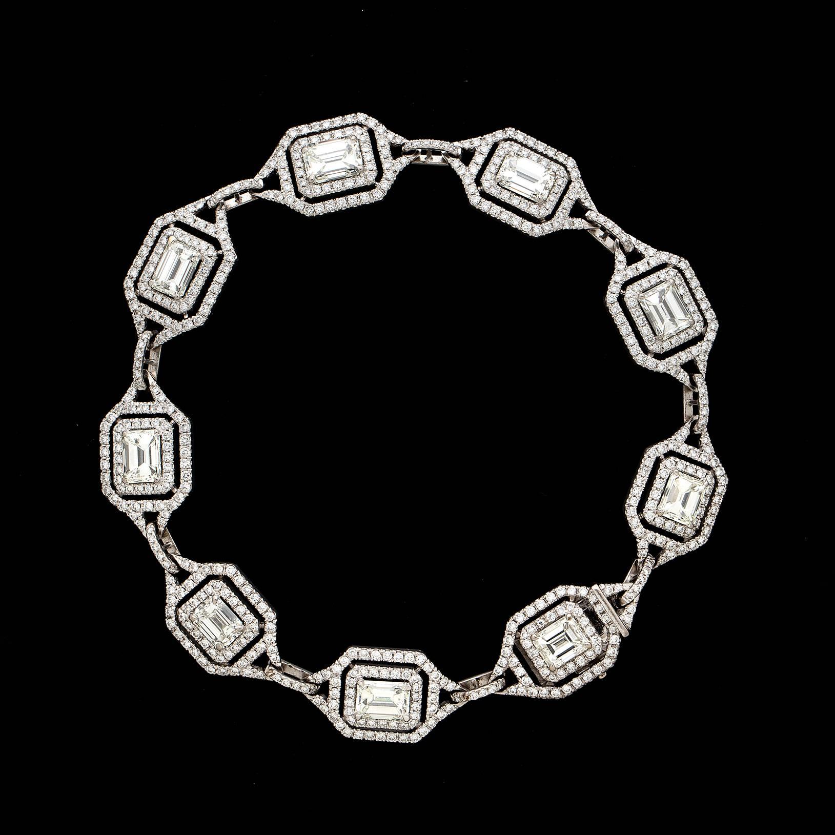 This elegant 18 karat white gold bracelet features 9 beautiful emerald cut diamonds weighing approximately 9.0 carats. These impressive clean and white stones are set among 600 round brilliant cut melee diamonds weighing approximately 3.0 carats.