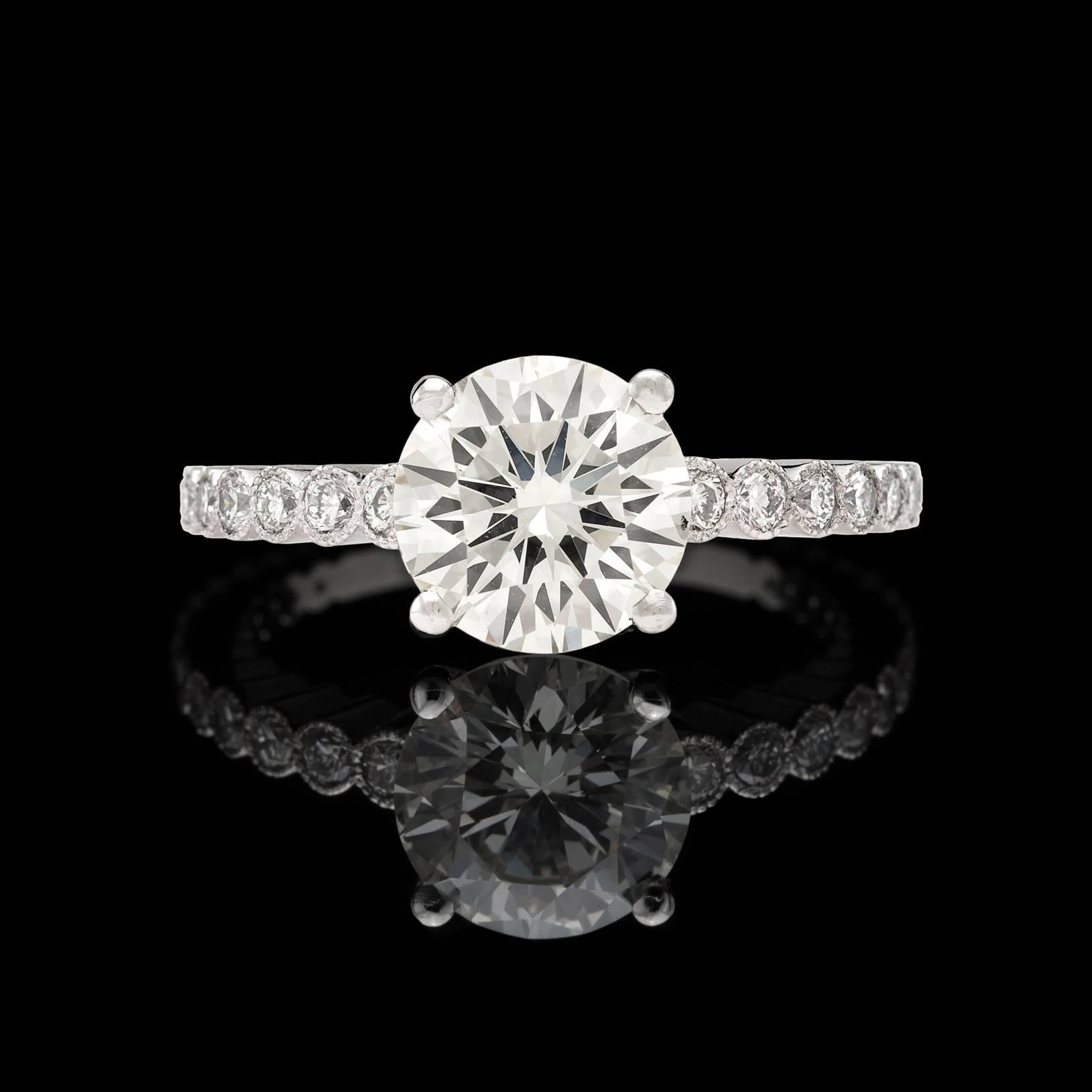 Handmade in France, this gorgeous custom Platinum mounting highlights a stunning 2.06 carat GIA graded L/VS2 Round Brilliant Cut Diamond flanked by 26 round diamonds for an additional 0.38 carats. This lovely center stone has exceptional sparkle and