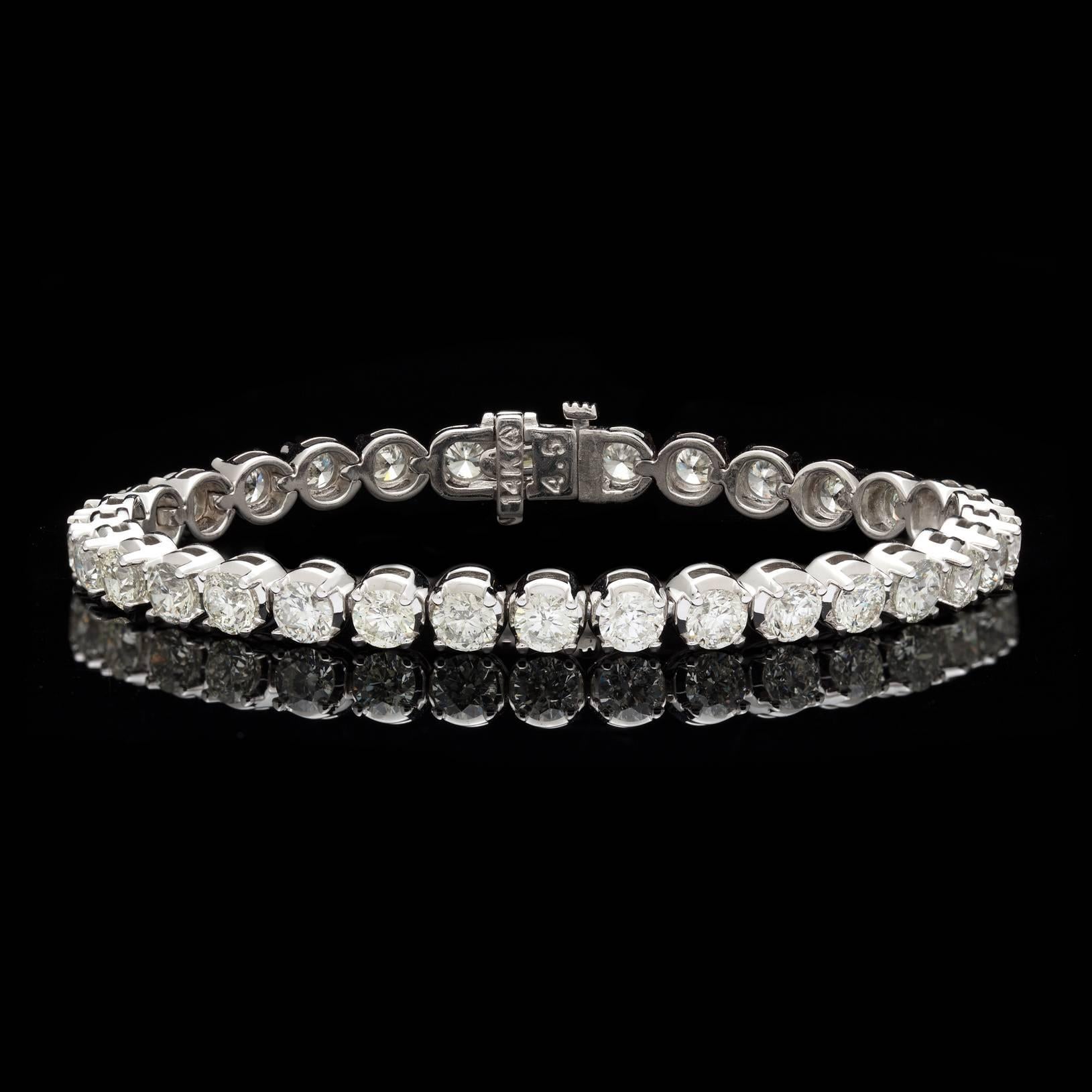 Impressive Diamond Tennis Bracelet featuring 32 fine Round Brilliant Cut Diamonds for a total weight of 12.70 carats. The diamond have phenomenal sparkle and fire, averaging H/I color and SI clarity. At 20.9 grams this 14kt White Gold beauty has