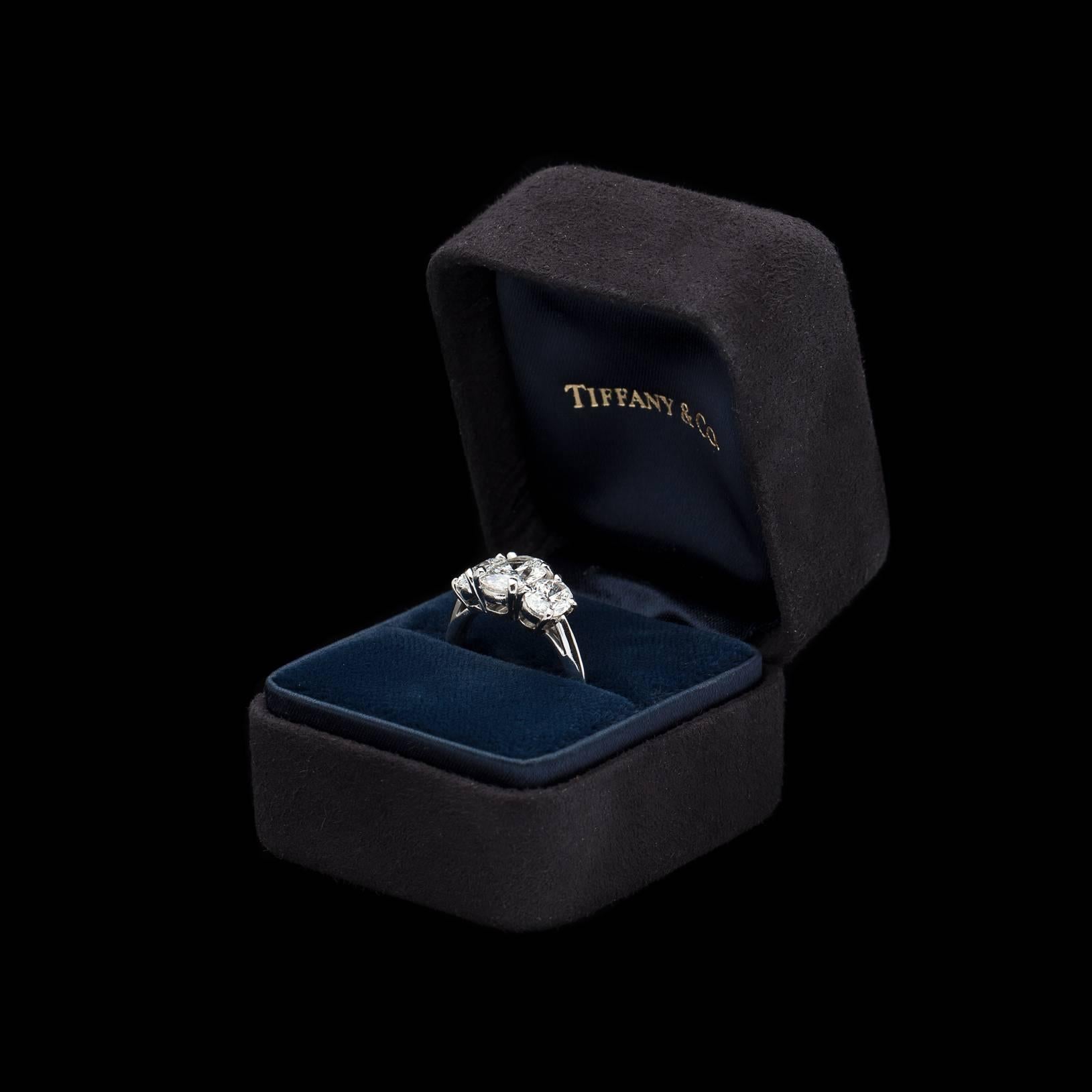 Breathtaking Three Stone Oval Cut Diamond Platinum Ring by the one and only Tiffany & Co. This stunner features F Color VVS Clarity Diamonds with a 2.45 carat total weight. The gorgeous center stone weighs 1.25 carats and is accompanied by GIA
