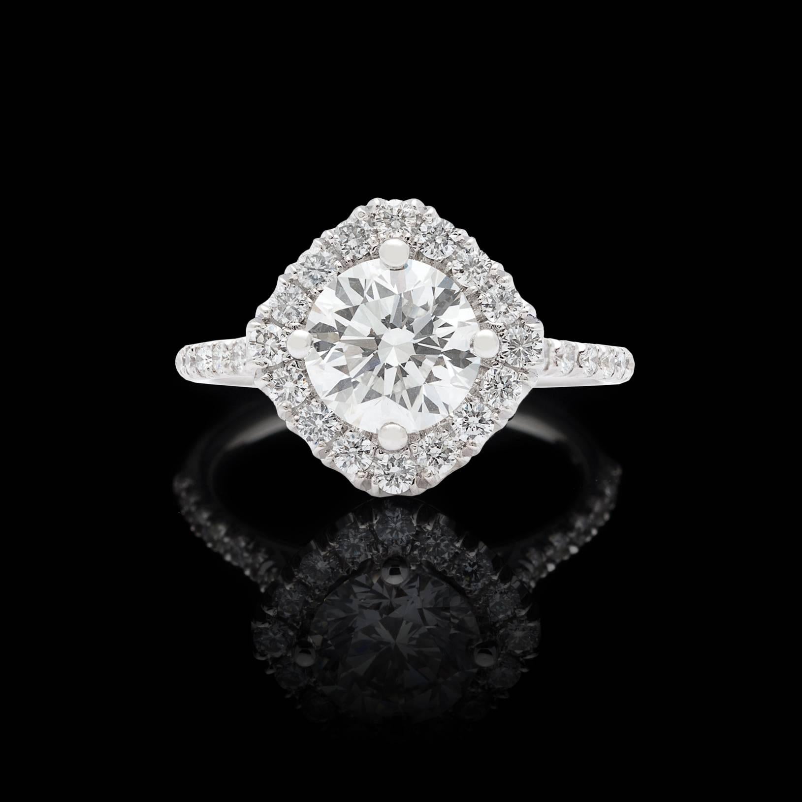 Stunning elegance meets exceptional quality in this handmade ring. A flashing 1.50 carat GIA graded H color VS1 clarity Round Brilliant Cut Diamond is perfectly set in this beautifully unique mounting, flanked by .65 carats of melee diamonds in the