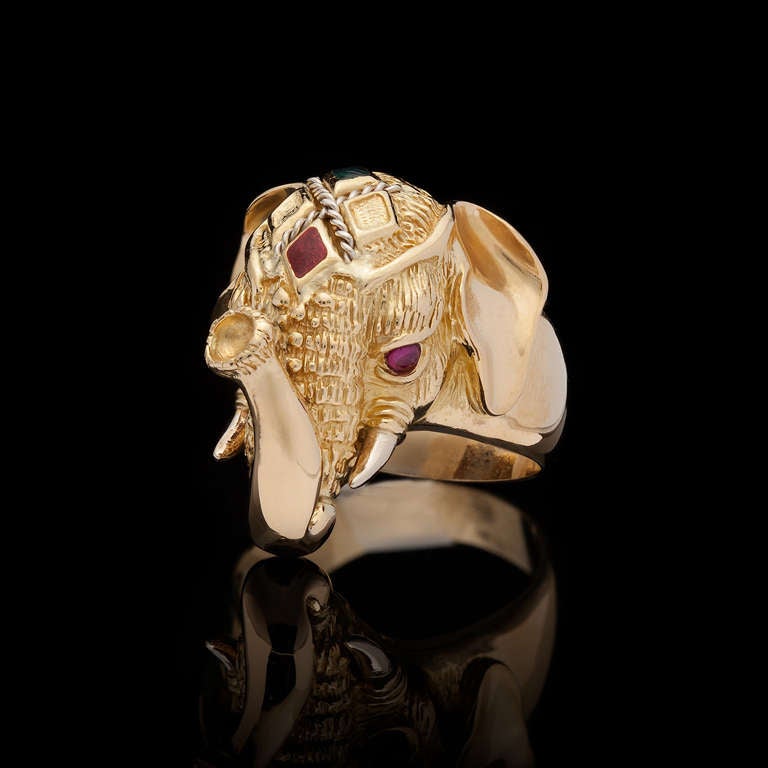 This 18K yellow gold Elephant ring is adorned with two cabochon Ruby eyes and two diamond shaped colored stones. The ring is a size 8 and totals 18.2 grams.