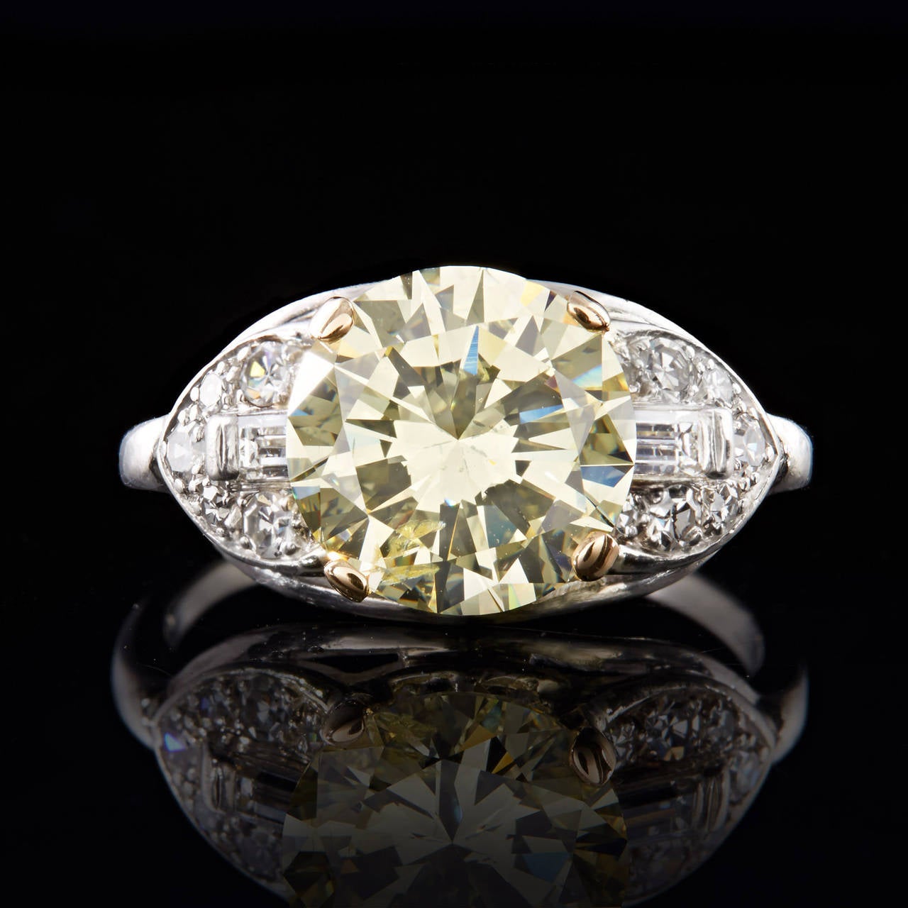 This Platinum Art Deco Diamond Ring features a 3.53 carat Light Yellow Center Stone SI2 clarity Round Brilliant Cut Diamond set in a 4 prong yellow gold mounting.  Accented around the center stone are F-G VS quality single cut diamonds and baguette