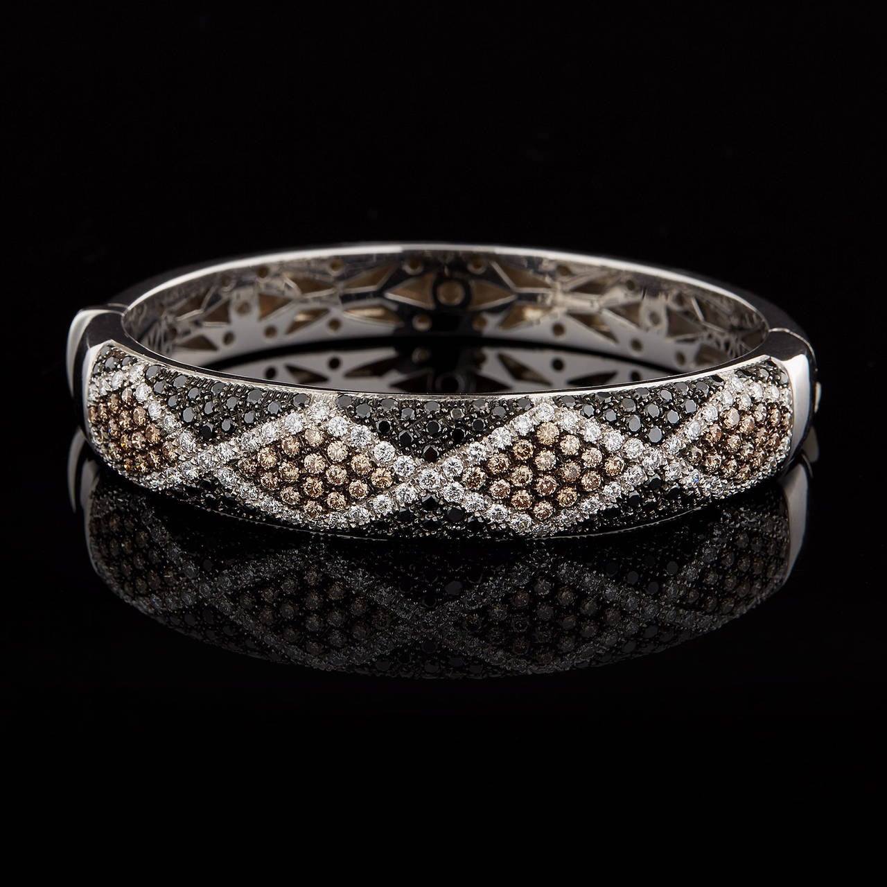 Salavetti 18Kt White Gold Bangle features 1.49 carats of Black Diamonds, 1.90 carats of Brown Diamonds, & 1.59 carats of White Diamonds Paved in a Diamond Pattern Design. The bangle fits a wrist size of 8 inches and has a tapered width of