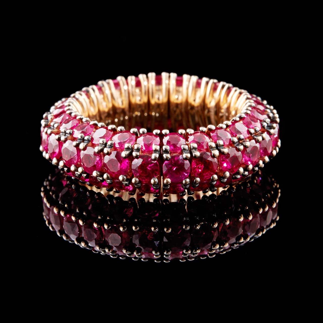 Mattia Cielo 18Kt Yellow Gold Flexible Universo 3 Pietre Band Ring with 6.65 Carat Total Weight of Rubies. This vibrant ruby red band is 7.2 mm in width & fits a finger size 6.25.  The total weight is 8.8 grams.