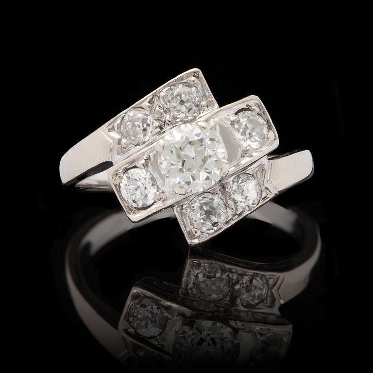 Vintage 14Kt White Gold Ring features 1 European Cut Diamond for approximately 0.55ct with I-J color and SI1 clarity accented by 6 Old Mine Cut diamonds for an additional 0.58cts.  Ring weighs 4.0 grams and is a size 7.0.