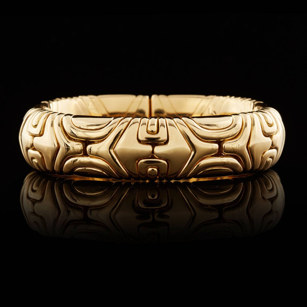 Bulgari Solid 18Kt Yellow Gold Flexible Bangle Bracelet from the Alveare Collection. This piece measures 15mm wide and approximately 7 inches around, weighing 115.9 grams.