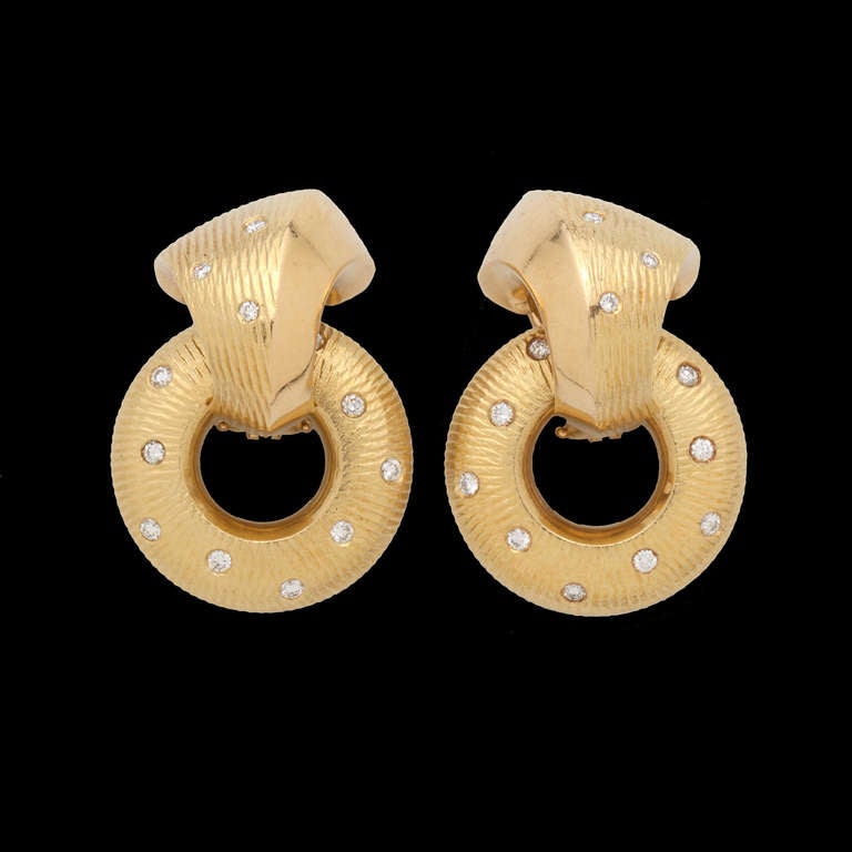 Paul Morelli 18k yellow gold clip-on diamond earrings features 20 round cut diamonds for approximately 0.20ct.  The earrings can be worn two ways,  measuring 31mm from top to bottom and 21.5mm at the widest point, when worn with as hoop drop, and
