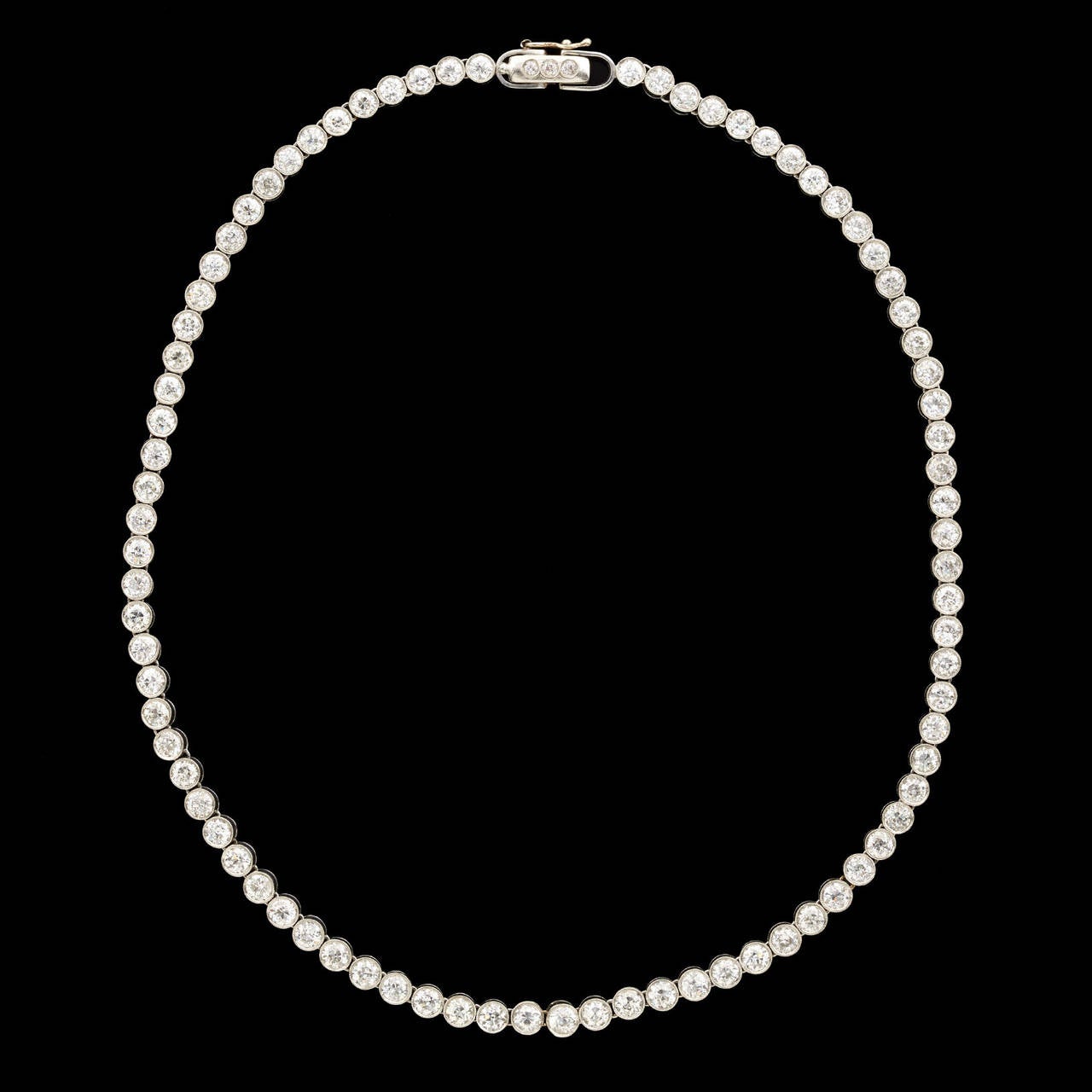 Vintage Line Necklace Features 85 Old Mine Cut Diamonds G Color and VS-SI Clarity, Weighing Approximately 20.00-ctw. The stones are bezel set in platinum with milgrain detail. The necklace is 16 inches long and 4.5mm wide and weighs 41.7 grams.