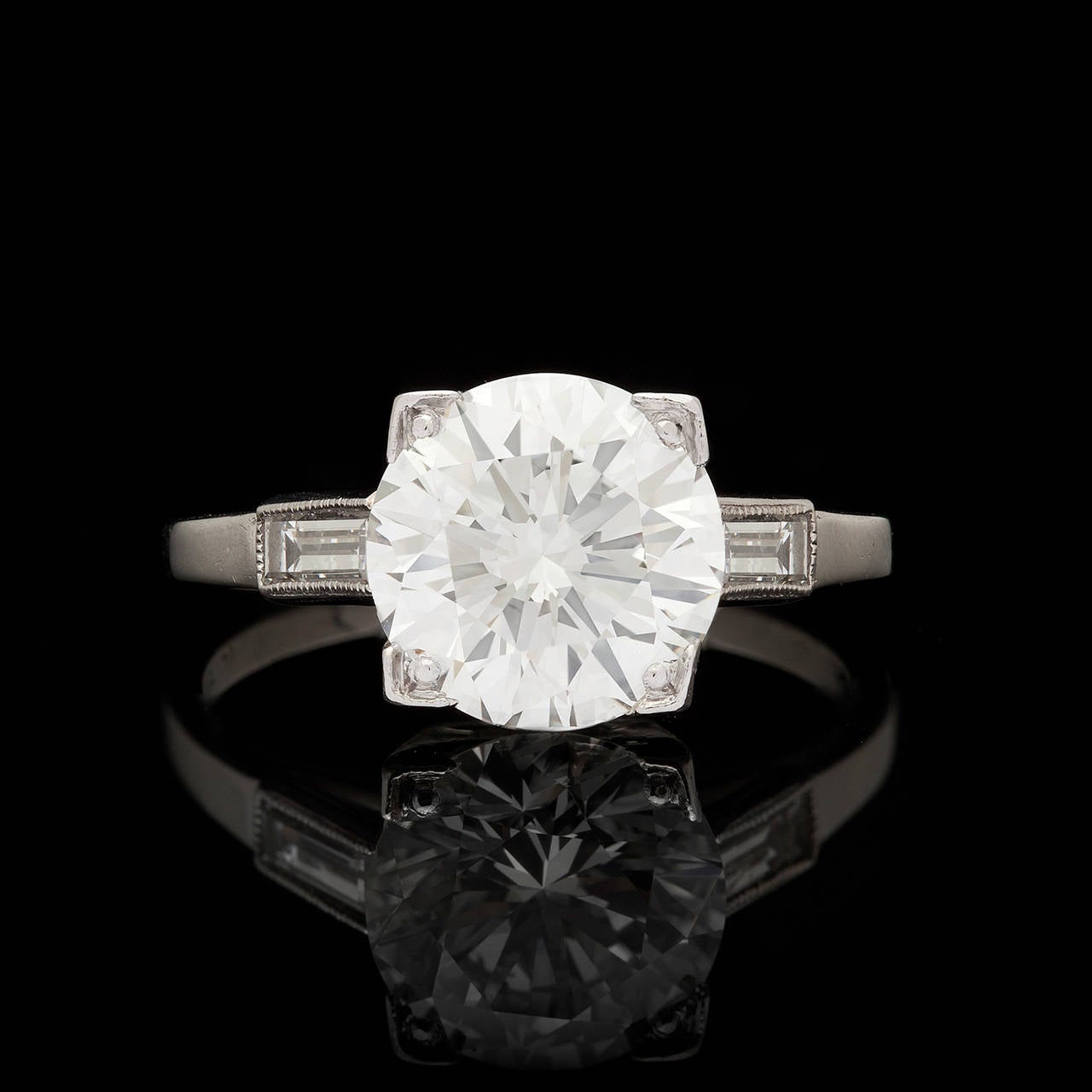 Vintage Platinum Setting, circa 1960s, Features a GIA 2.27 Carat J Color and VS1 Clarity Round Brilliant Cut Diamond Enhanced by Two Elegant Baguette Diamonds. The ring is a size 4.75, with room for adjustment, and weighs a total of 3.5 grams.