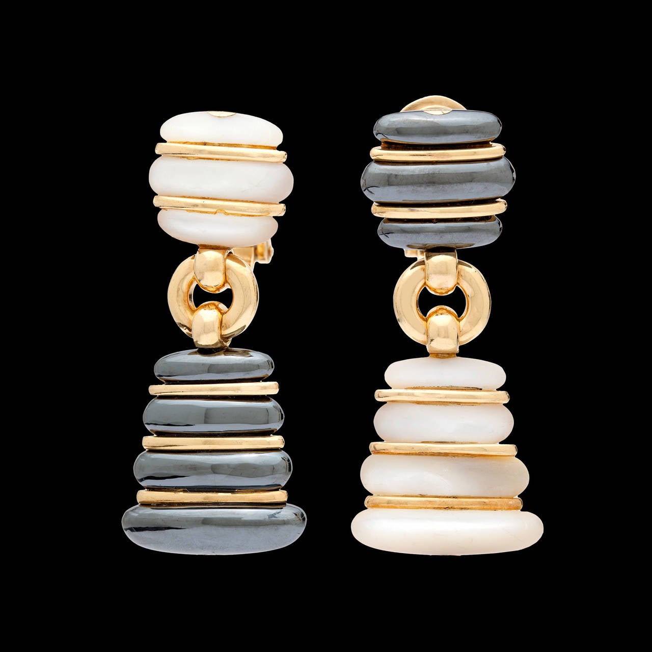 Estate Bulgari Hematite and Mother of Pearl Dangle Earrings set in 18Kt Yellow Gold. The earrings measure approximately 1.50 inches long. The width tapers from .50 to .75 inches. The total weight of the pair is 26.4 grams.