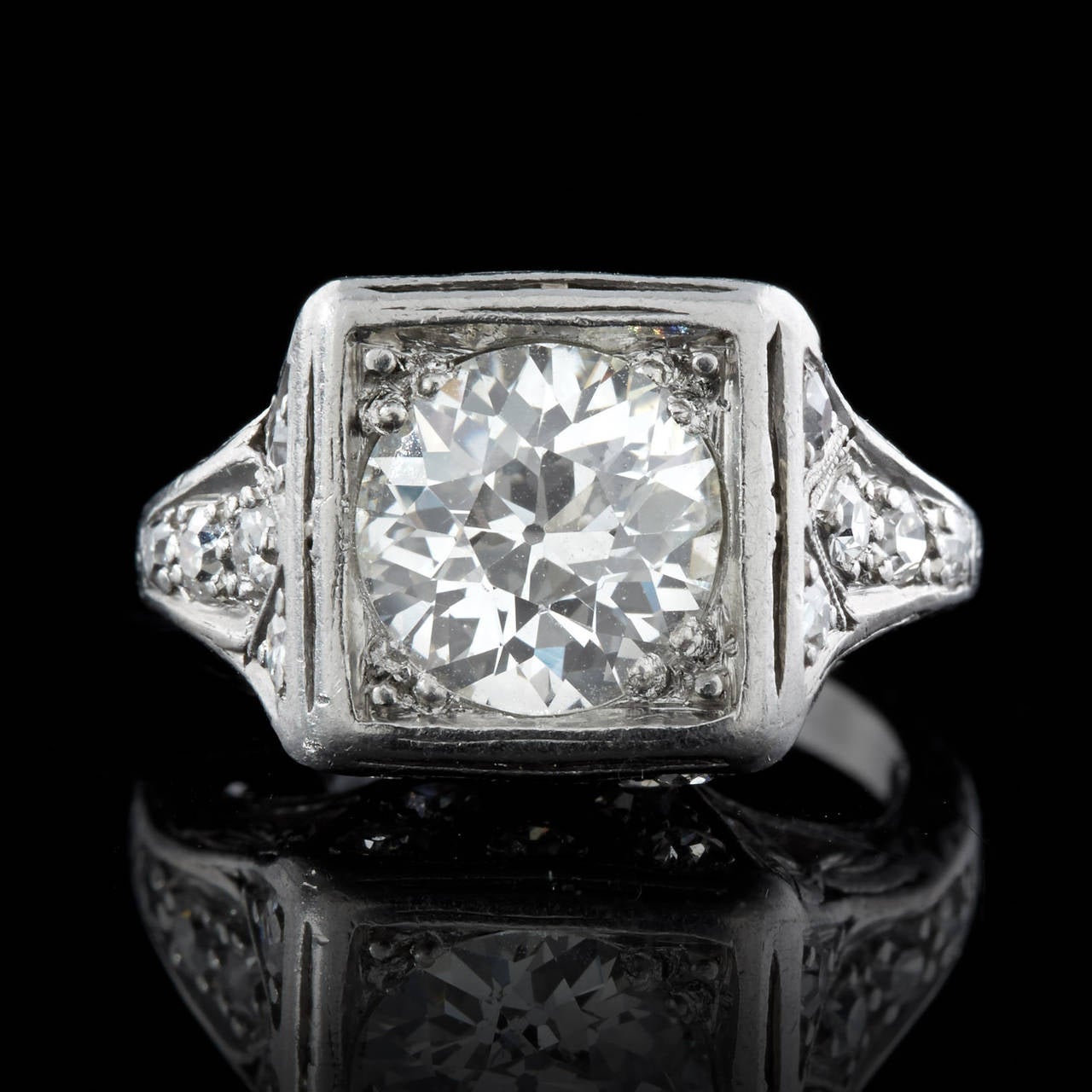 Estate 1920s Platinum Ring features a center 1.85 Carat I Color SI1 Clarity Old European Cut Diamond. There are 20 single cut diamonds totaling 0.54 carats accenting the top half of ring with openwork, milgrain detail, and engraving on the ring