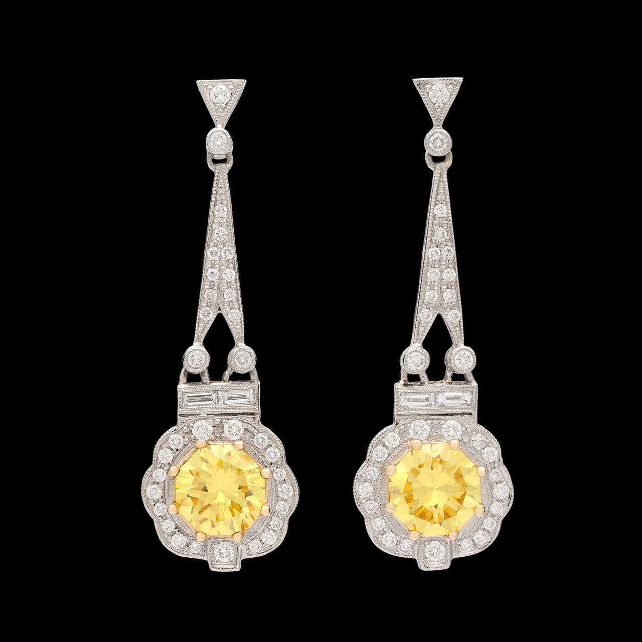Stunning GIA Natural Fancy Intense Yellow Diamond Earrings in Deco Style Platinum and 18Kt Yellow Gold Settings. The two evenly colored yellow diamonds are shaped in a unique octagonal modified brilliant cut. The fancy intense yellow diamonds total