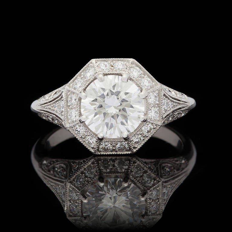 Custom made ring featuring a 1.52ct (F, VVS2) Round Brilliant Cut diamond, complete with GIA Grading Report for the center stone, accented by an octagonal pave diamond border and diamond accented floral motif platinum ring, mounted with 8 prongs.