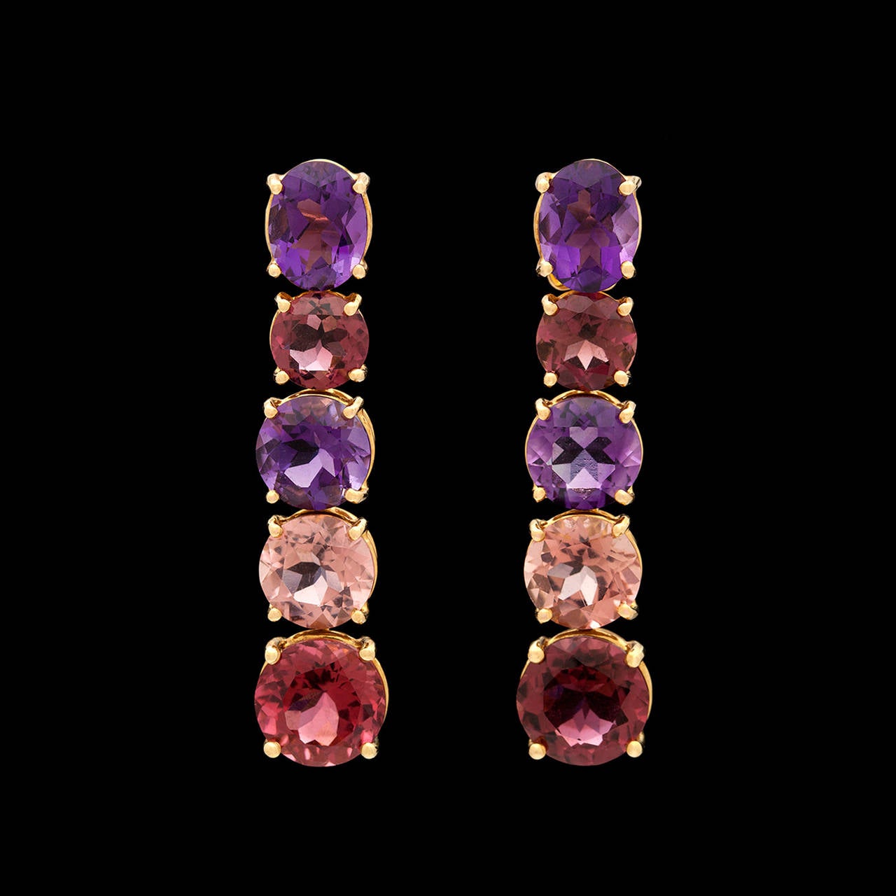 Asprey Chaos 18Kt Yellow Gold Dangle Earrings Feature Ten Oval and Round Brilliant Cut Gemstones in Shades of Purple and Pink. The earrings are approximately 1.5 inches long and total 9.7 grams. Made in Italy.