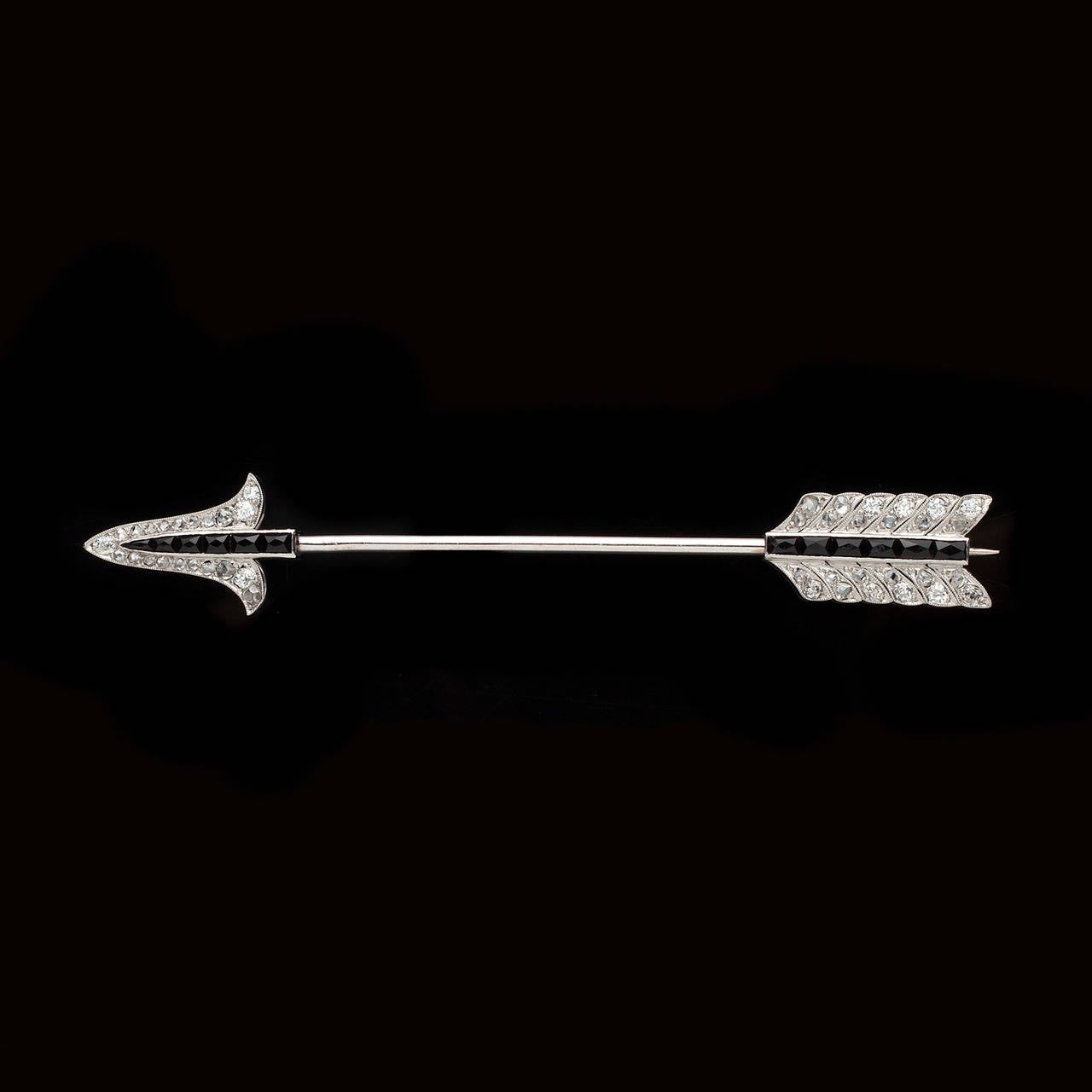 French Art Deco J.E. Caldwell Jabot Pin Features 1.00ct of Old Mine and Rose Cut Diamonds Along with a Row of Black Sapphires Accenting a Sophisticated Platinum Arrow. The 3 inch long pin totals 8.9 grams.