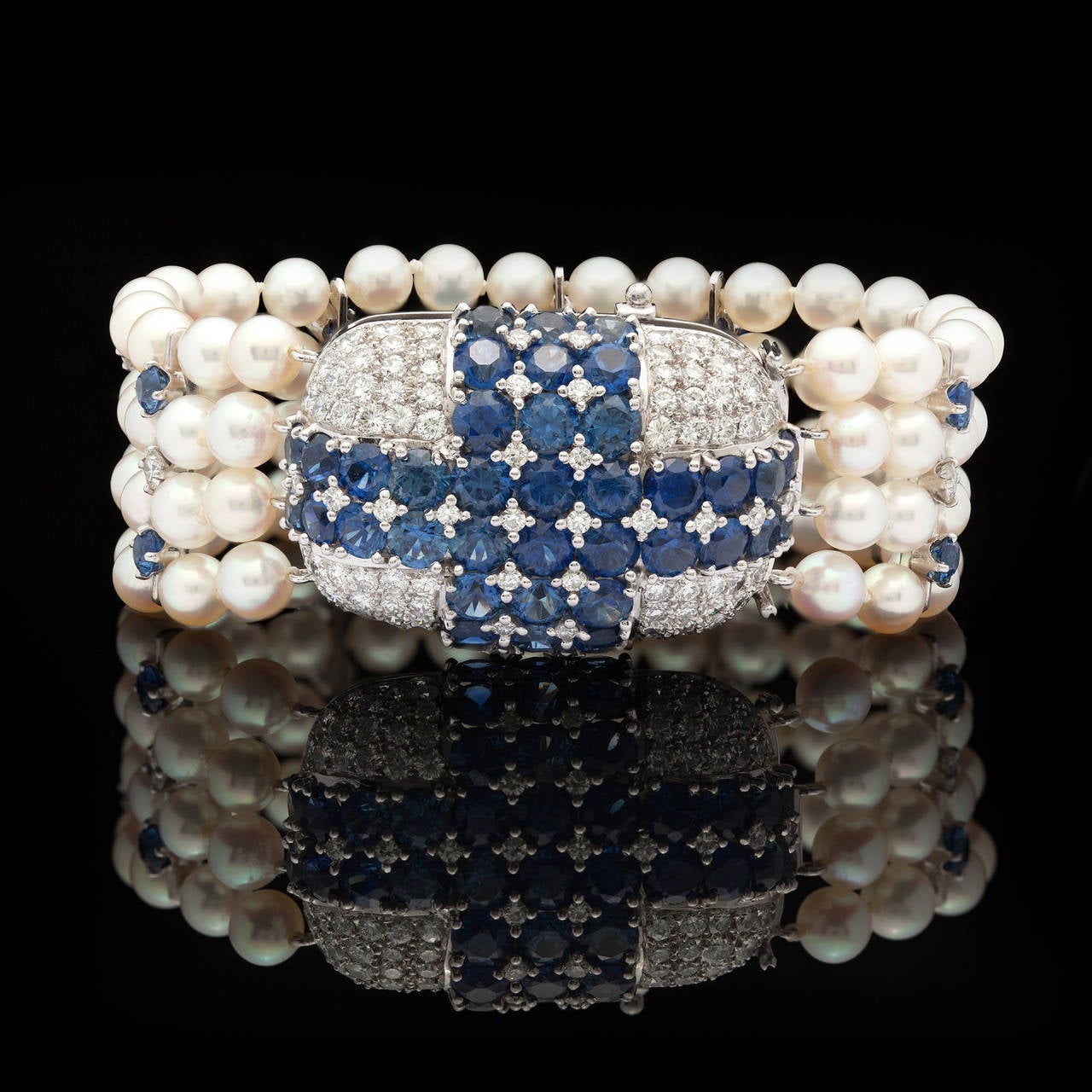 Bracelet Features Strands of Cultured Pearls Enhanced by Round Brilliant Cut Diamonds and Sapphires on a Jeweled Platinum Clasp, signed Ruser. There are approximately 3.28 cts. of diamonds and 8.00 cts. of sapphires decorating this piece. The