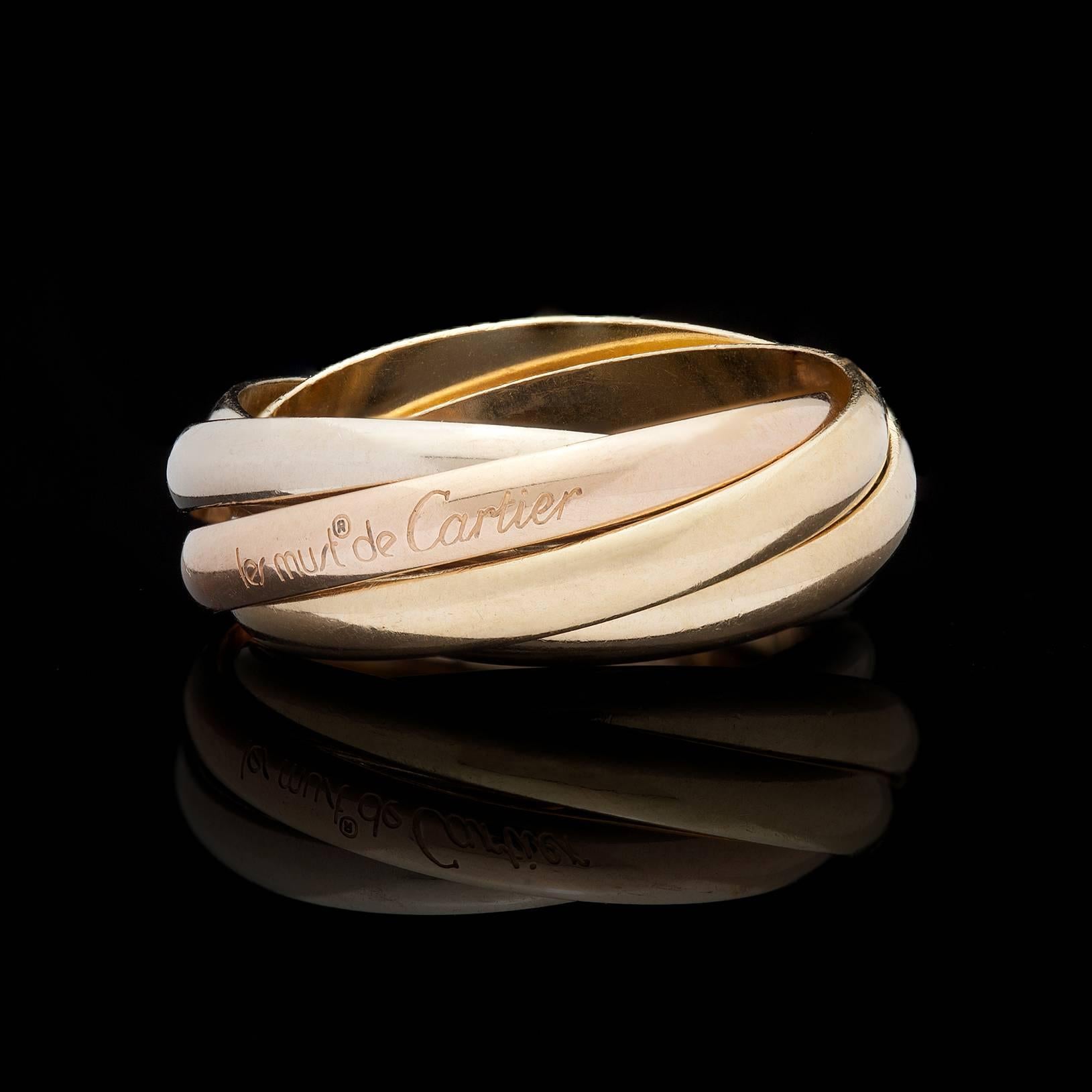This classic 18Kt Gold les must de Cartier 5-Band Trinity Ring consists of 2 Yellow Bands, 2 White Bands, and 1 Rose Gold Band. Ring size is a European 57 which is the circumference in MM and converts to a US size 8. The width of each band is 2.7mm,