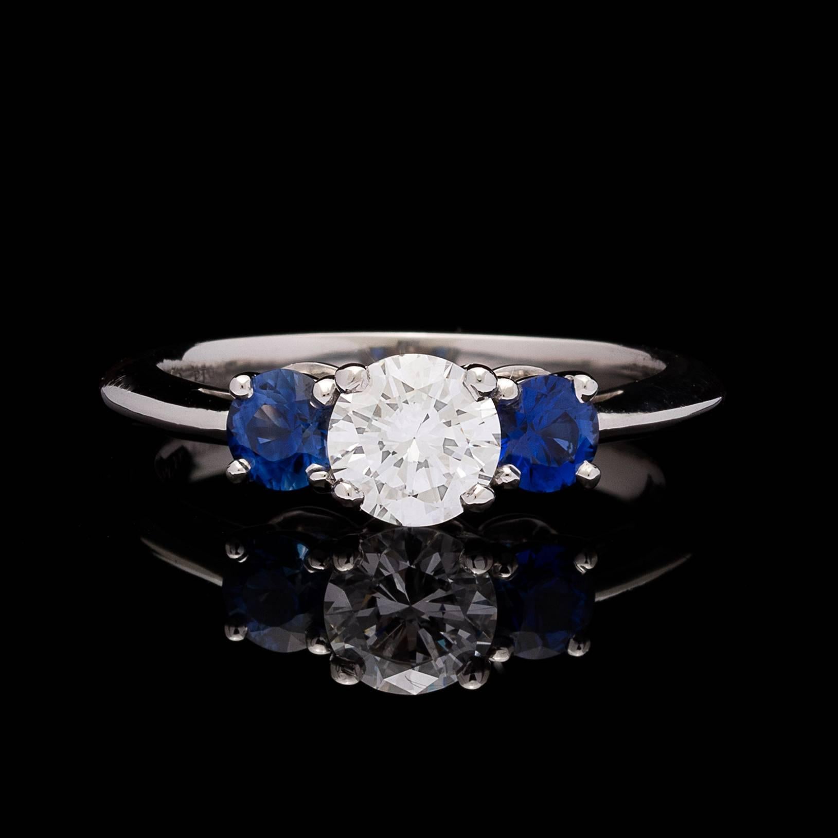 Tiffany & Co. 3-Stone Platinum ring features a GIA graded Round Brilliant Cut Diamond weighing 0.62 carats, with quality E color, and SI1 clarity.  Report # 2175209308 accompanies the diamond.   The 2 round sapphires totals approximately 0.50