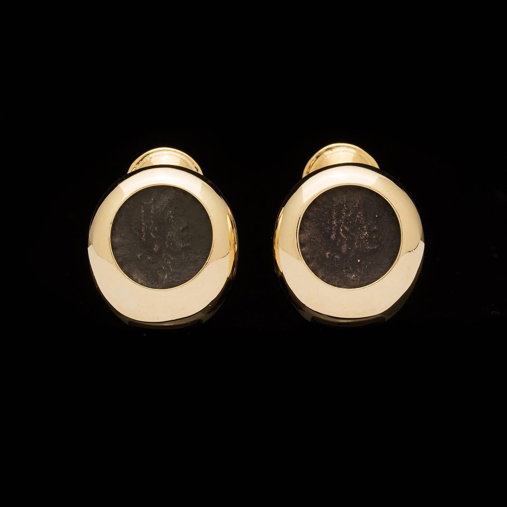 Estate earrings feature two Roman coins set in bold 18k yellow gold clips.  The earrings measure 3/4 of an inch by  5/8 of an inch, and weigh 14.3 grams total.