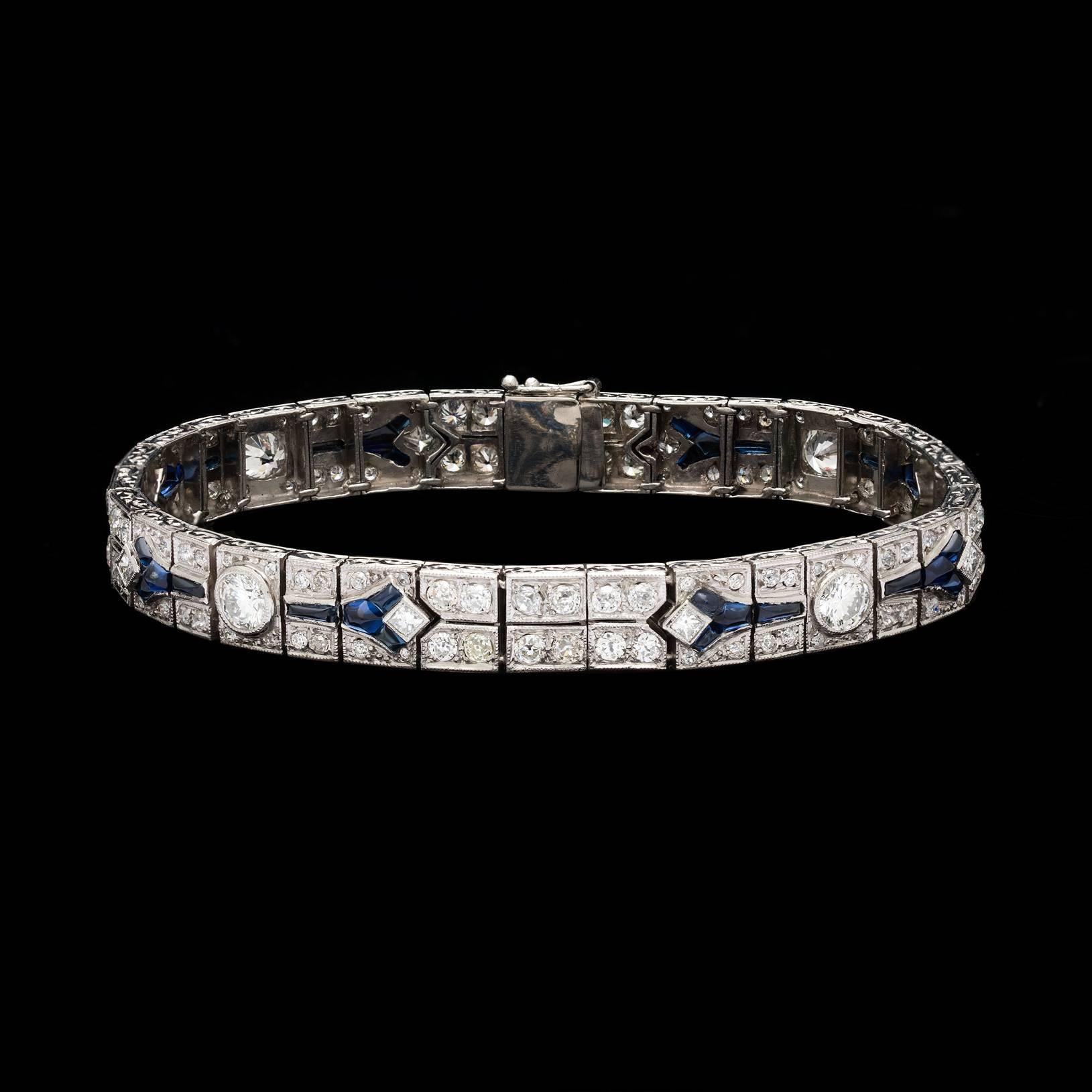 Platinum Art Deco Bracelet features a mix of old european, princess, & modern brilliant cut diamonds totaling 6.92 carats. Accenting the bracelet are calibre cut cabochon blue sapphires. The bracelet measures 7.5″ in length and 8.3mm in width. Total