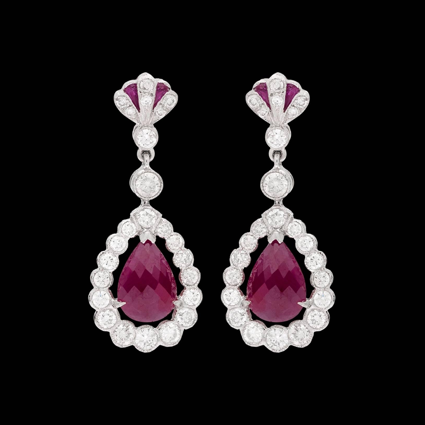 18k white gold dangle earrings features teardrop briolette cut rubies from Burma for a total of 3.45 carats. The surrounding diamonds totals 1.39 carats. At the top of the earring measuring 1.13″ drop are accent calbre cut rubies. Total weight of