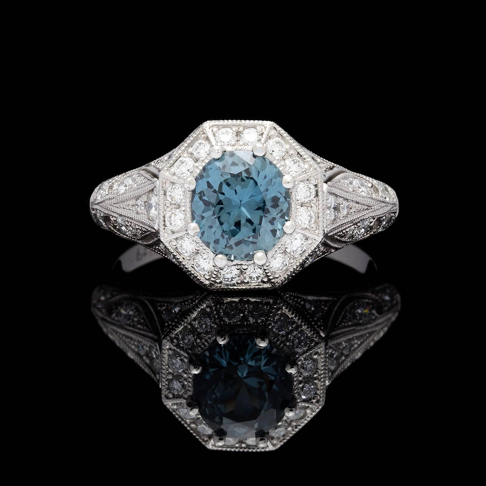 Platinum diamond openwork ring features a 1.53 carat GIA grayish-blue oval mixed brilliant cut sapphire accompanied by report # 1106710503. Top face of the ring is octagonal in shape detailed with milgrain edges. The brilliance of the ring is