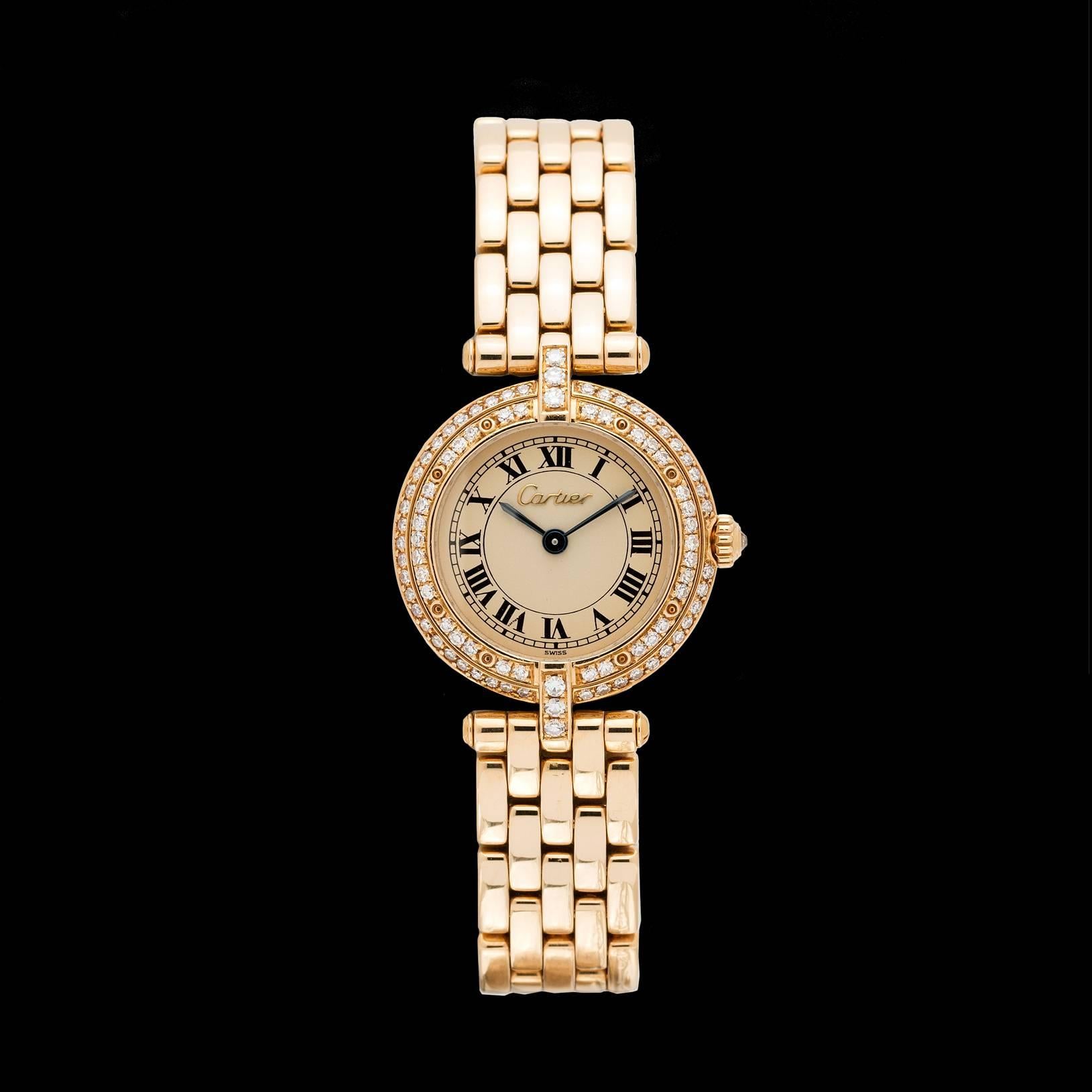 Cartier 18k yellow gold ladies Panthere collection model Vendome with diamond bezel & crown. The dial is a cream color with blue-steel hands detailed with a gold colored 'Cartier' signature name. Watch movement is a quartz operated by a battery. The
