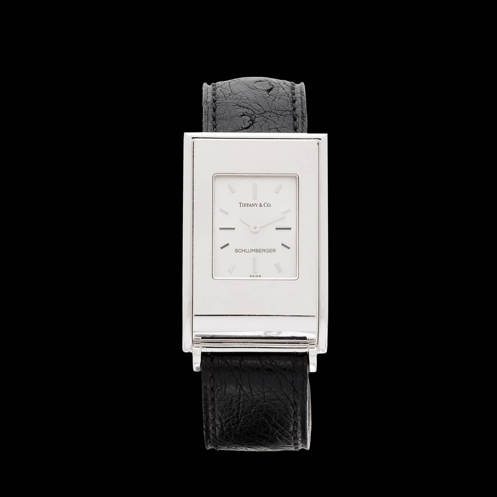 Tiffany & Co. Schlumberger ladies wristwatch features a solid 18k white gold 33.5mm by 23mm rectangular case with high polish on a Tiffany & Co. black ostrich leather bracelet. This analog watch has a Swiss made quartz movement for accurate time