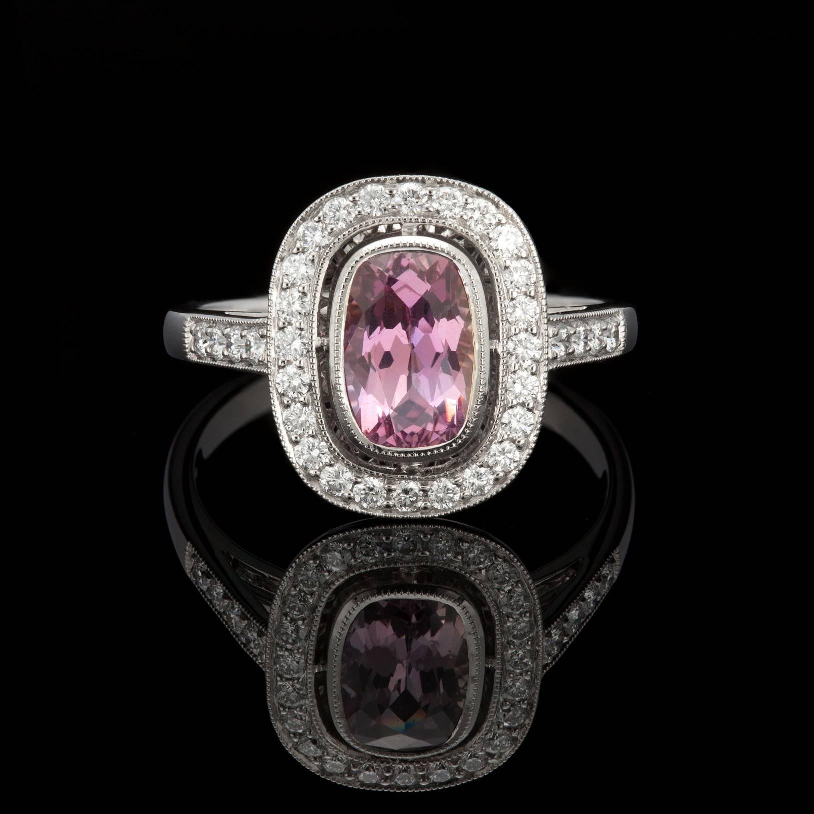 Platinum halo ring featuring a GIA 1.25ct rectangular modified brilliant cushion-cut brownish pink sapphire and 32 round brilliant cut diamonds weighing 0.32cttw. The total weight of the ring is 5.0 grams. GIA report 2101359662 accompanies the