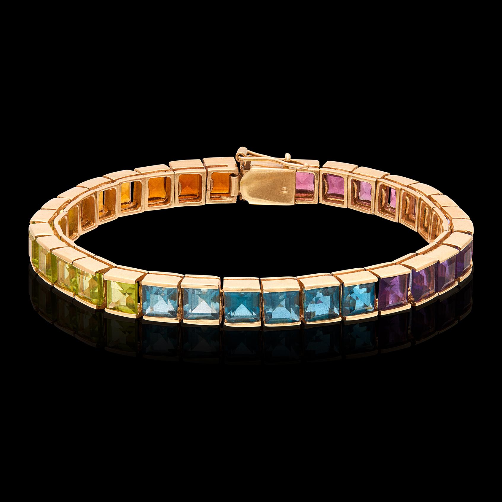 ¡Esto es vintage en estado puro! De la década de 1990, está engastada en canal con piedras semipreciosas cuadradas de un arco iris de colores, como amatista, topacio, peridoto, turmalina, citrino y granate. La pulsera pesa 21,97 gramos y mide 6 3/4